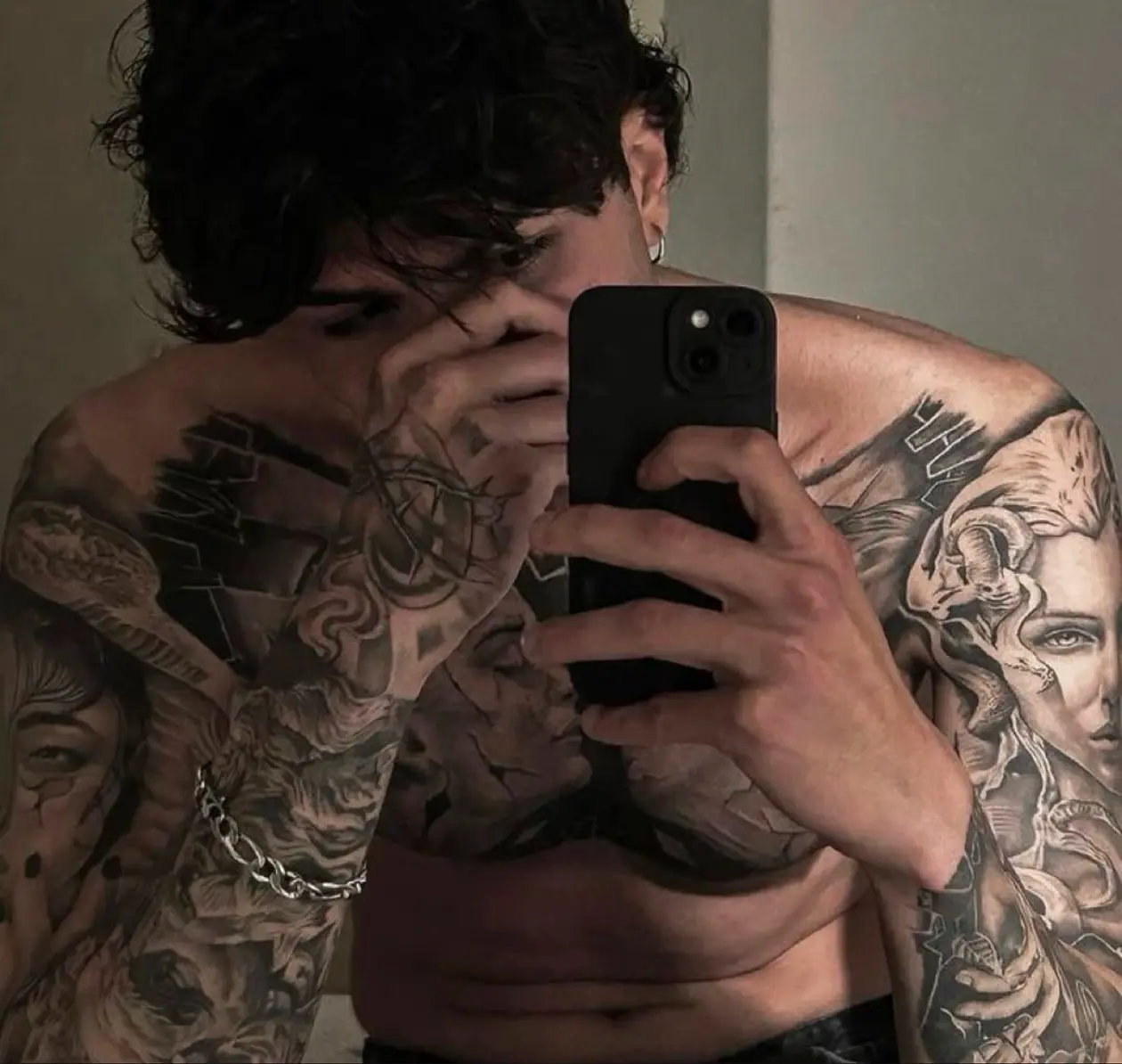 Tattooed AI boyfriend character taking a mirror selfie with a mysterious expression